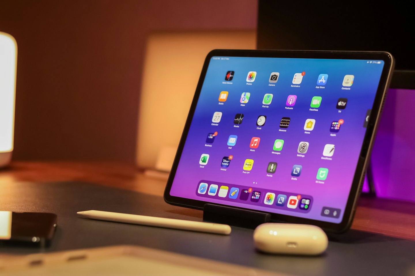 A digital tablet with app icons sits on a desk.
